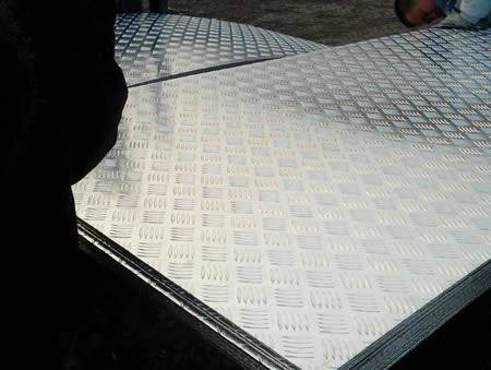 Many rectangular aluminum checker plates are in workshop.