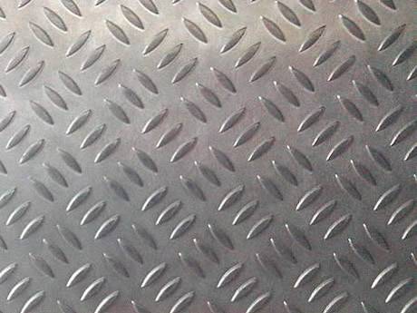 A piece of aluminum checker plate with short rice shaped projections.