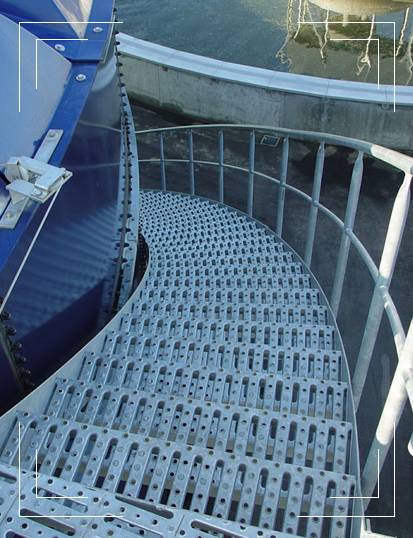 Stainless steel perforated safety grating for stair treads around a big tower.