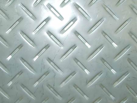 A piece of stainless steel checker plate with raised long strip projections.