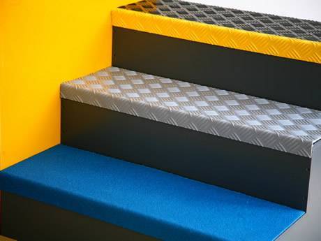 Three stair treads with FRP grit surface, a piece of checker plate and a steel grating.