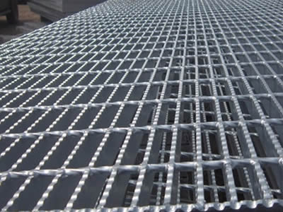 A large serrated galvanized welded steel grating is placed in level.