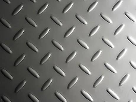A piece of stainless steel checker plate with raised small rice projections.