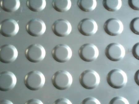 A section of checker plate with round projections and the flat bottom.