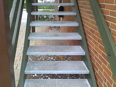 An exterior stair is formed from aluminum traction-grip safety grating.