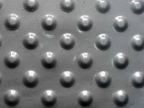 A silver white checker plate with round projections.