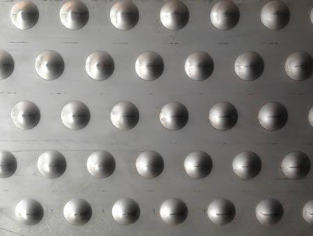 A section of checker plate with big round projections.