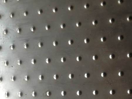 A section of checker plate with small round projections.