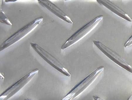 A section of silver white checker plate with raised long strip projections.
