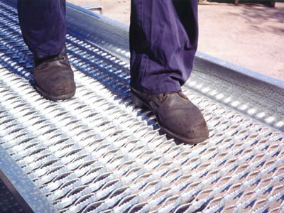 A people walking on a galvanized diamond-strut safety grating.